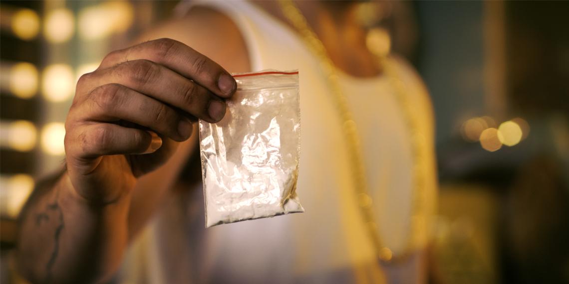 a man holding a bag of heroin