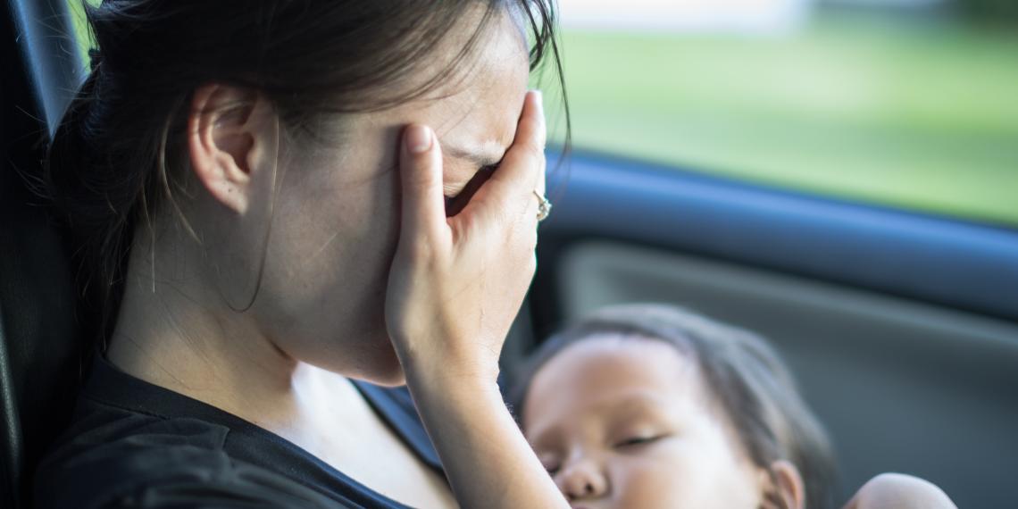 Worried woman in car with child
