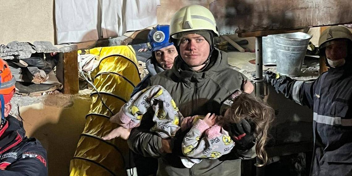 Sergeant Daniel Degenhart holds the girl in his arms who was rescued by AFDRU (Austrian Forces Disaster Relief Unit) soldiers on Friday night.