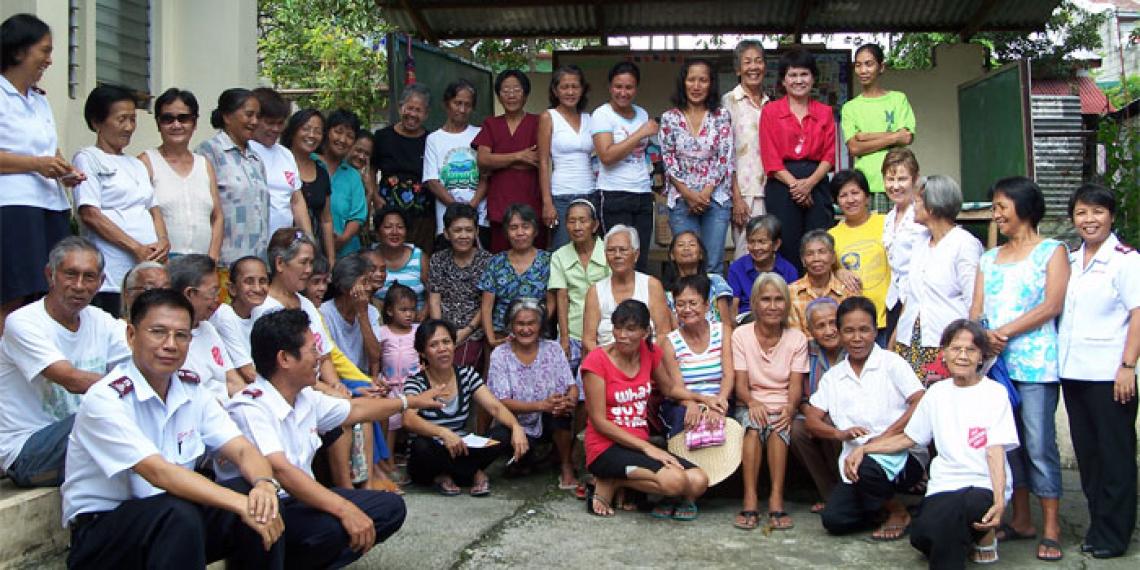 Mjr Vyvyenne Noakes with widows and elderly people helped at the Bagong Silong Corps feeding programme.