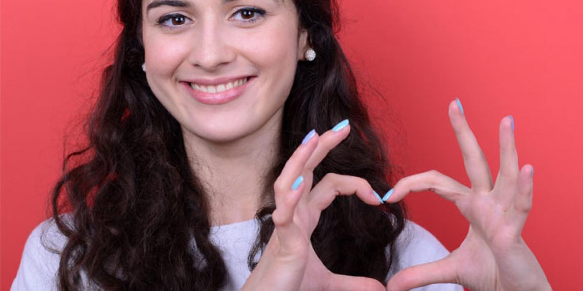 A girl making a heart symbol with her hands