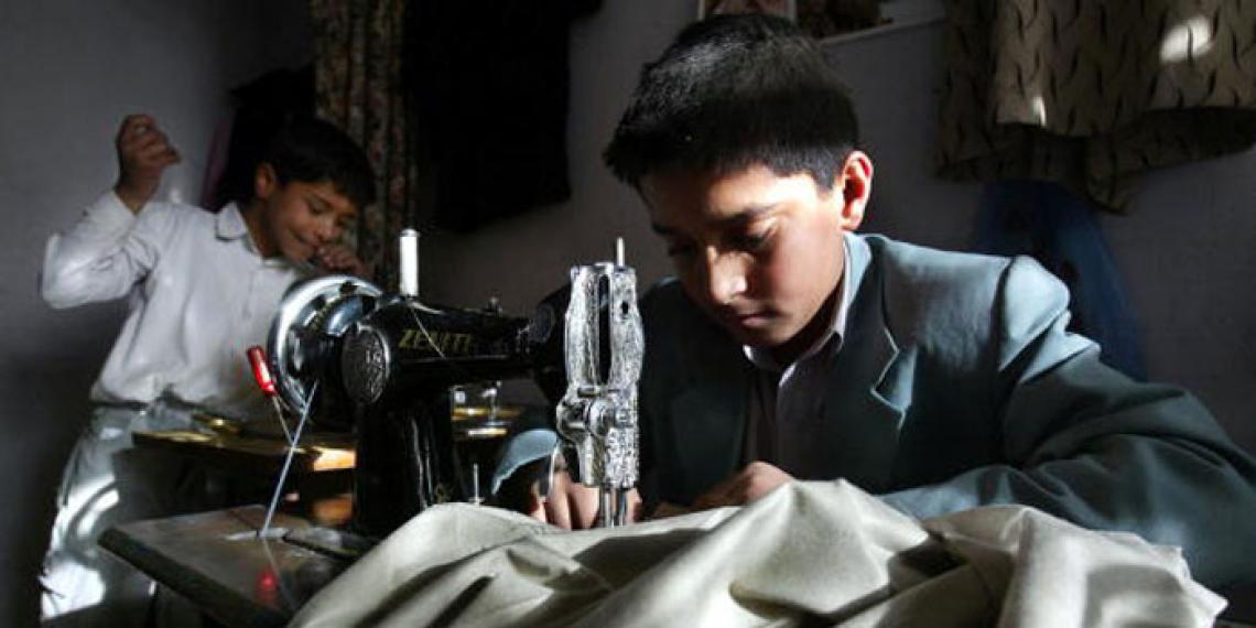 Two boys (aged 10 and 13 ) sew clothing at the Sajaad Tailor shop in Kabul, Afghanistan. 