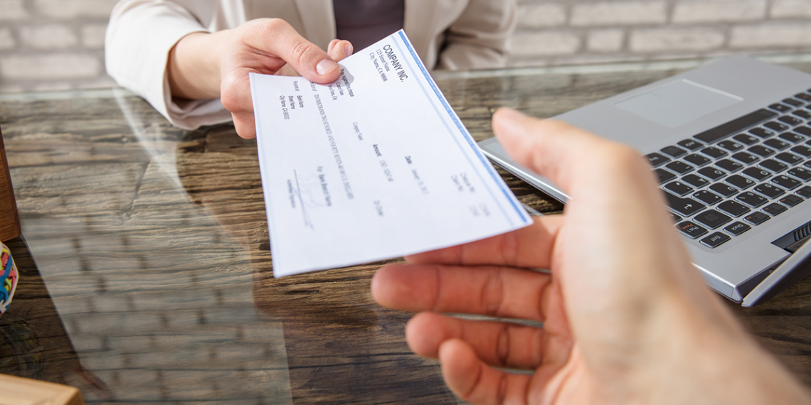 a person handing over their payroll cheque