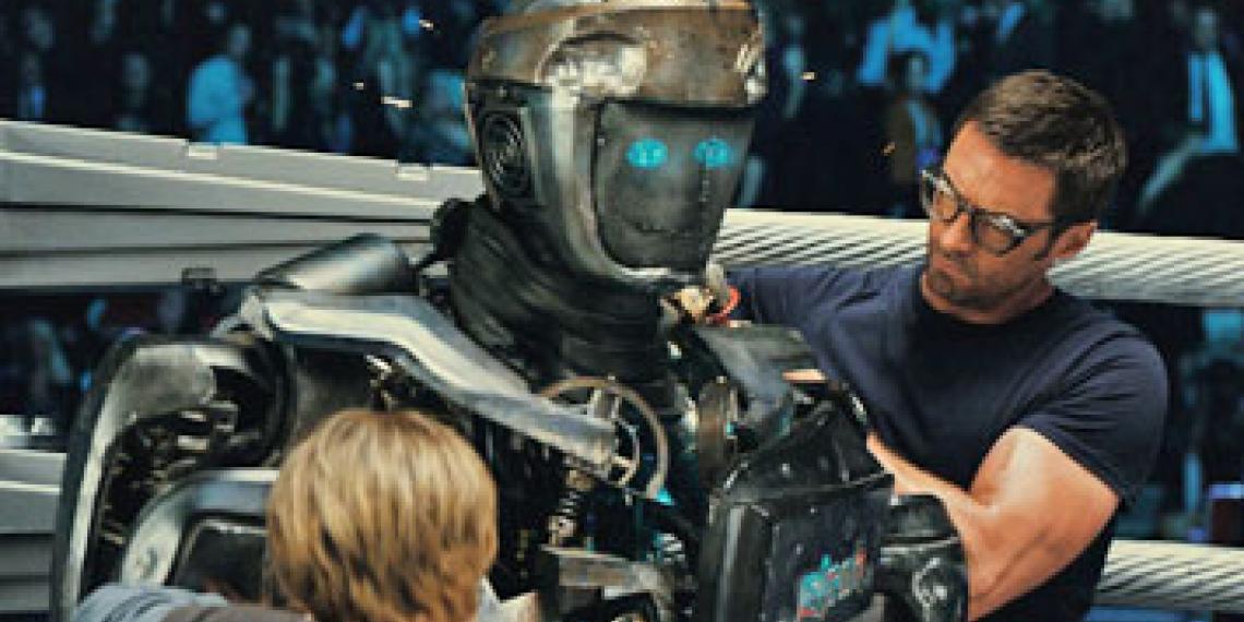 Charlie (Hugh Jackman) and his son, Max (Dakota Goyo) attend to their robot boxer, Atom.
